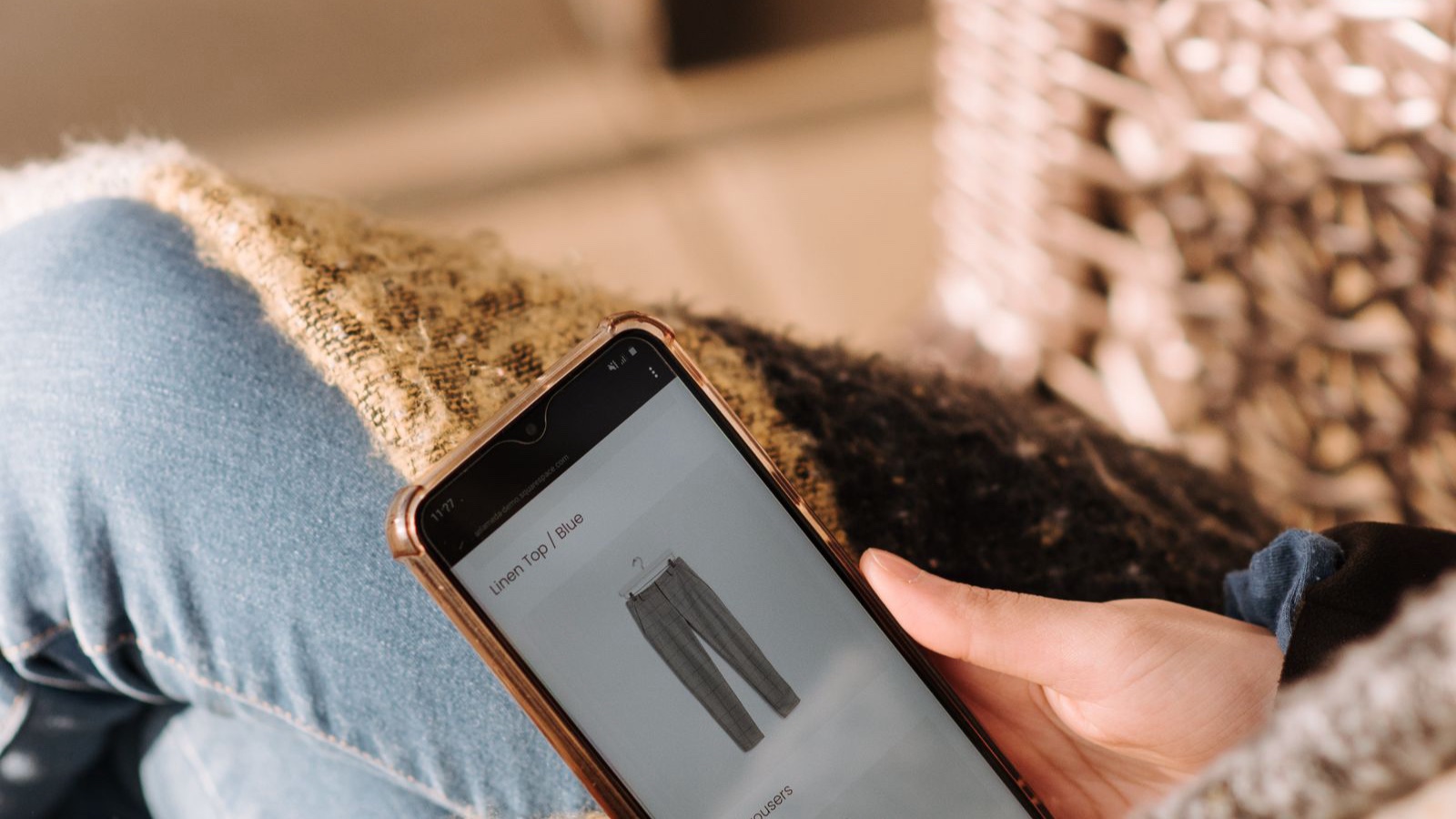 Close-up of a person browsing clothing products on a phone