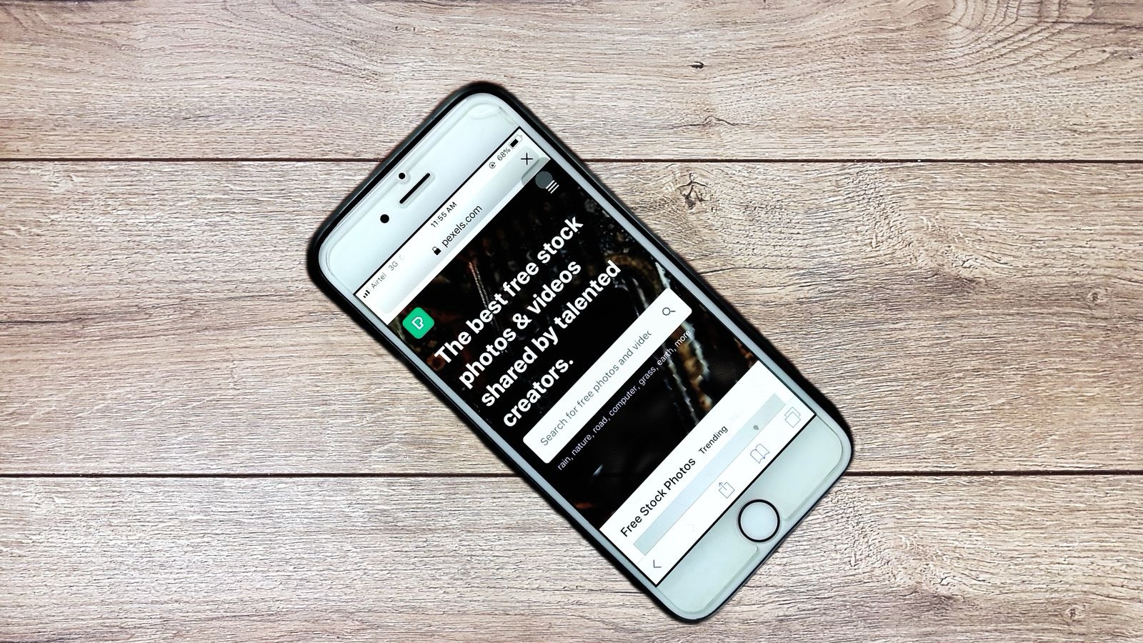 Top view contemporary mobile phone with opened website on screen placed on wooden table