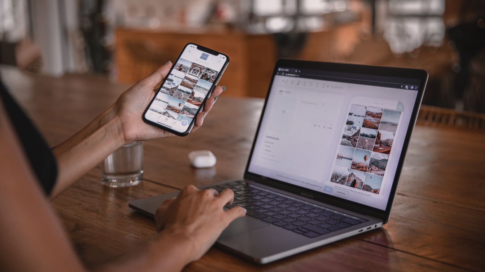Woman edits social media content on phone and laptop at a cafe in Bali.