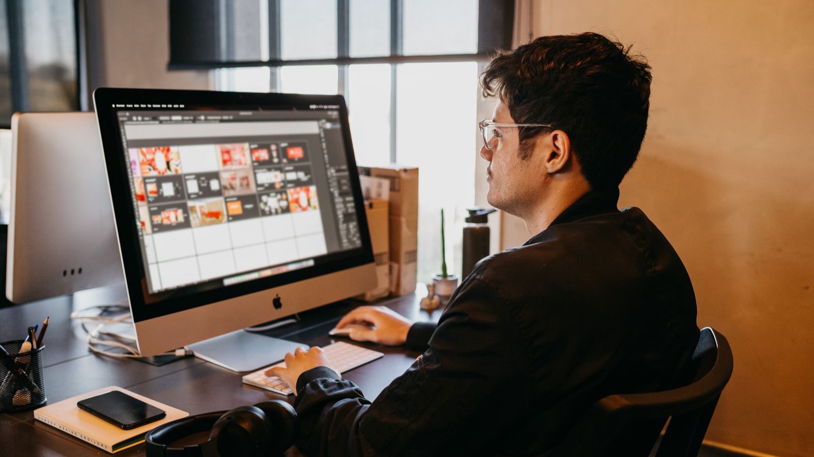 A designer reviewing visual layouts on a desktop monitor