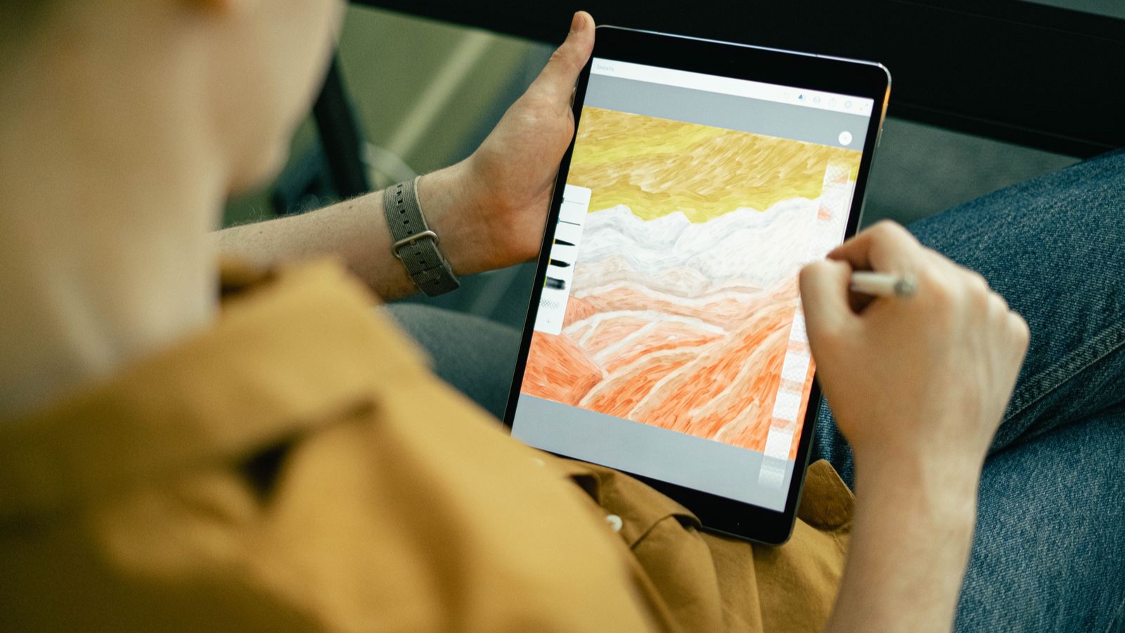 A person drawing a colourful illustration on a tablet with a stylus