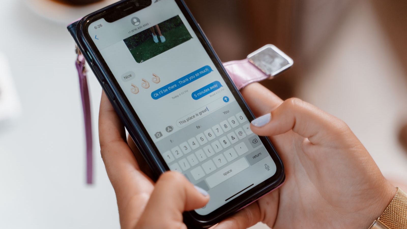 Hands typing a message on a smartphone