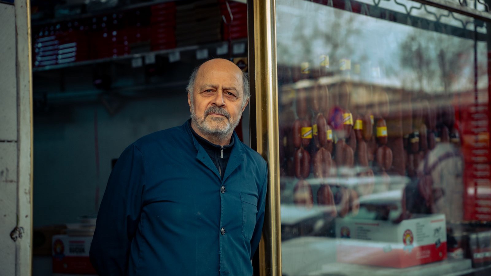 A shopkeeper standing in the entrance of his shop